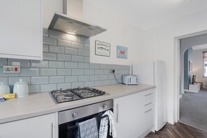 Eine moderne Küche mit Gaskochfeld, Toaster und Kühlschrank.