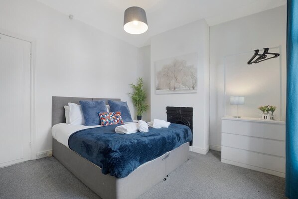 A modern bedroom with a bed, bedside table, lamp, and artwork. - 2BR in Brighton Road With Wifi Parking Smart TV (Darlington)