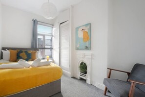 A bedroom with a bed, a chair, a painting, and a fireplace. - 2BR in Brighton Road With Wifi Parking Smart TV (Darlington)