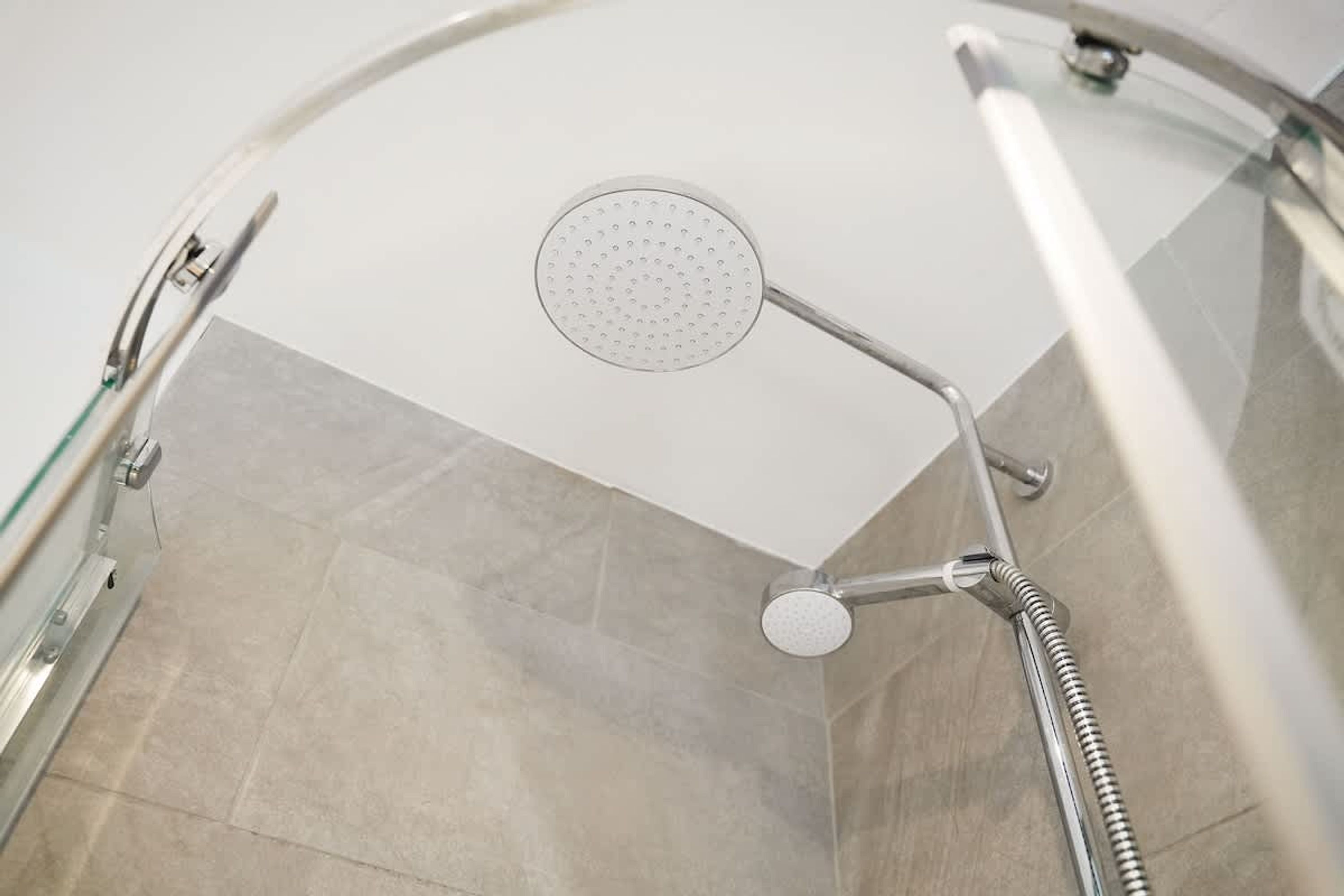 A shower with a handheld showerhead mounted on a flexible hose.