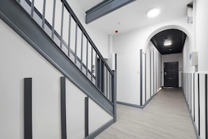 Ein modernes Interieur mit Treppe, Flur und einer Tür.