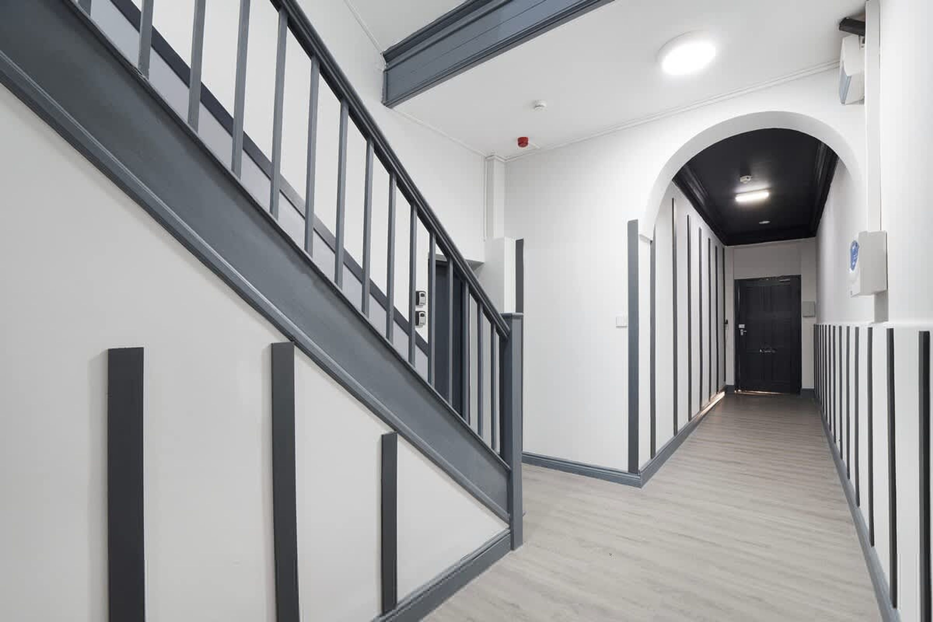 Ein zeitgemäßes Interieur mit einer Treppe, einem Flur und einer Tür.