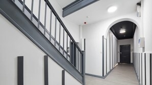 Et moderne interiør med trappe, gang og dør.