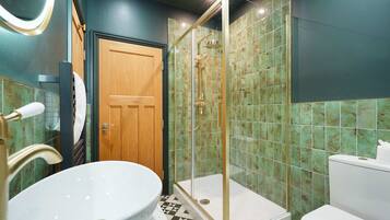 A bathroom with a freestanding bathtub, a shower enclosure, and a toilet.