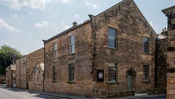 A historic stone building with multiple windows and a clock.