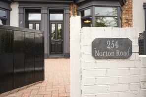 Ein Hausnummernschild an einer weißen Ziegelwand, das '254 Norton Road' zeigt.