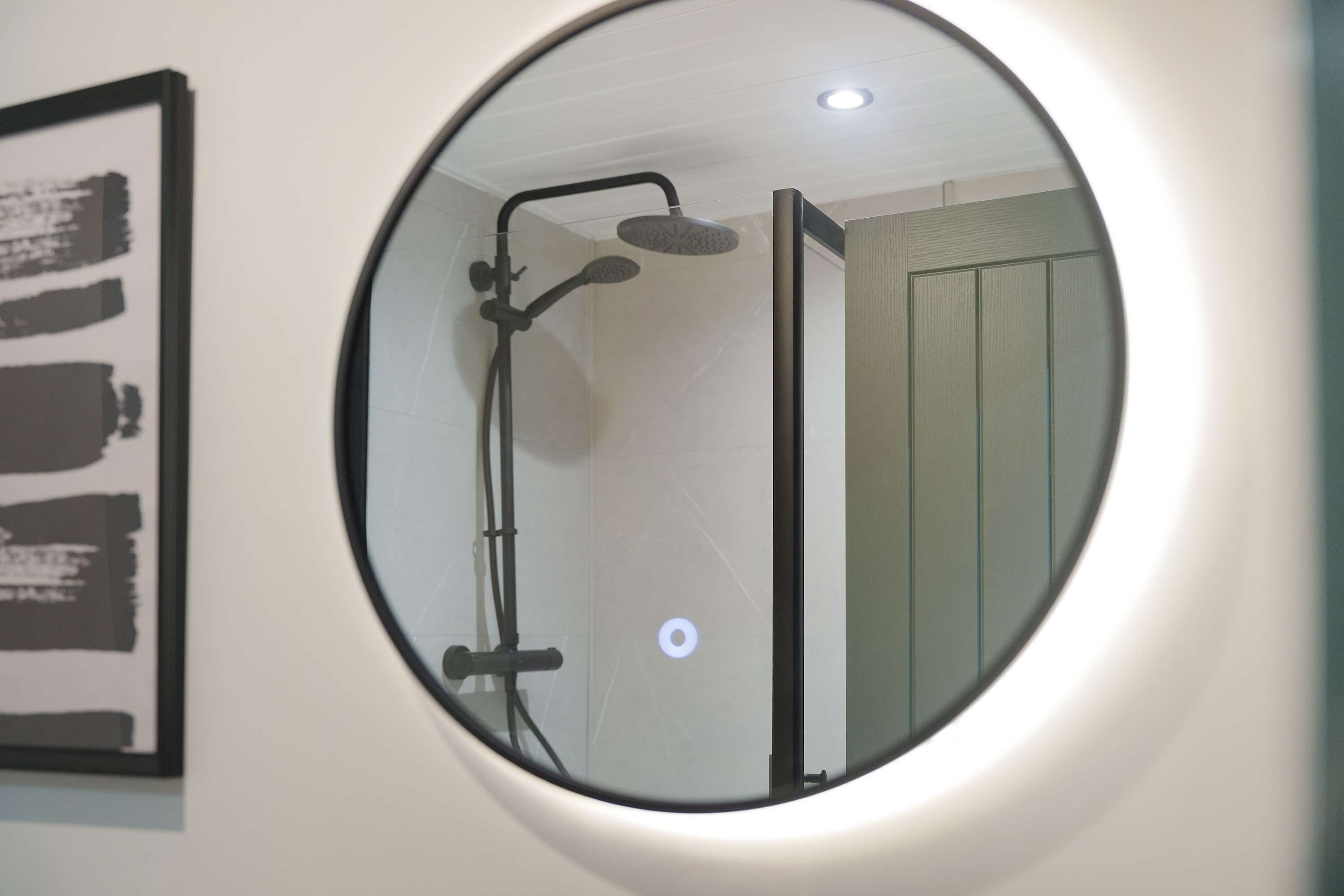 Ein Badezimmer mit Dusche, Toilette und Spiegel.