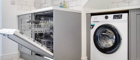 A compact laundry area with a front-loading washing machine and a dishwasher.