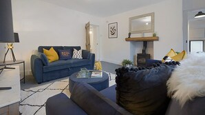 Uma sala de estar moderna com sofá, mesa de centro e lareira.