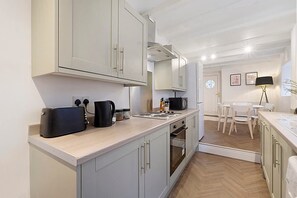 A modern kitchen with light grey cabinets, a black coffee maker, and a microwave. - Detached Three Bedroom Family Home Hot Tub Stay (Barnard Castle)