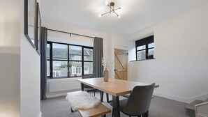 Quarto moderno com uma janela grande, uma mesa de jantar e um banco.