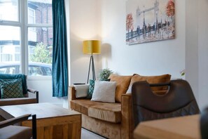 Ein Wohnzimmer mit einer Couch, einem Couchtisch, einer Lampe und einem Stadtbild.
