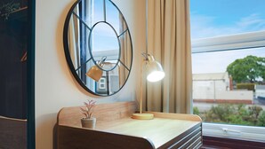 A room with a wooden bench, a round mirror, a desk with a lamp, and a view of the outside through a window. - Bright 4BR Norton Getaway Sleeps 7 by Stay With Us (Stockton-on-Tees)