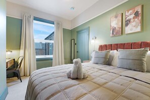 Une chambre à coucher comprenant un lit, une chaise, un bureau, une fenêtre avec des rideaux et deux lampes fixées au mur.