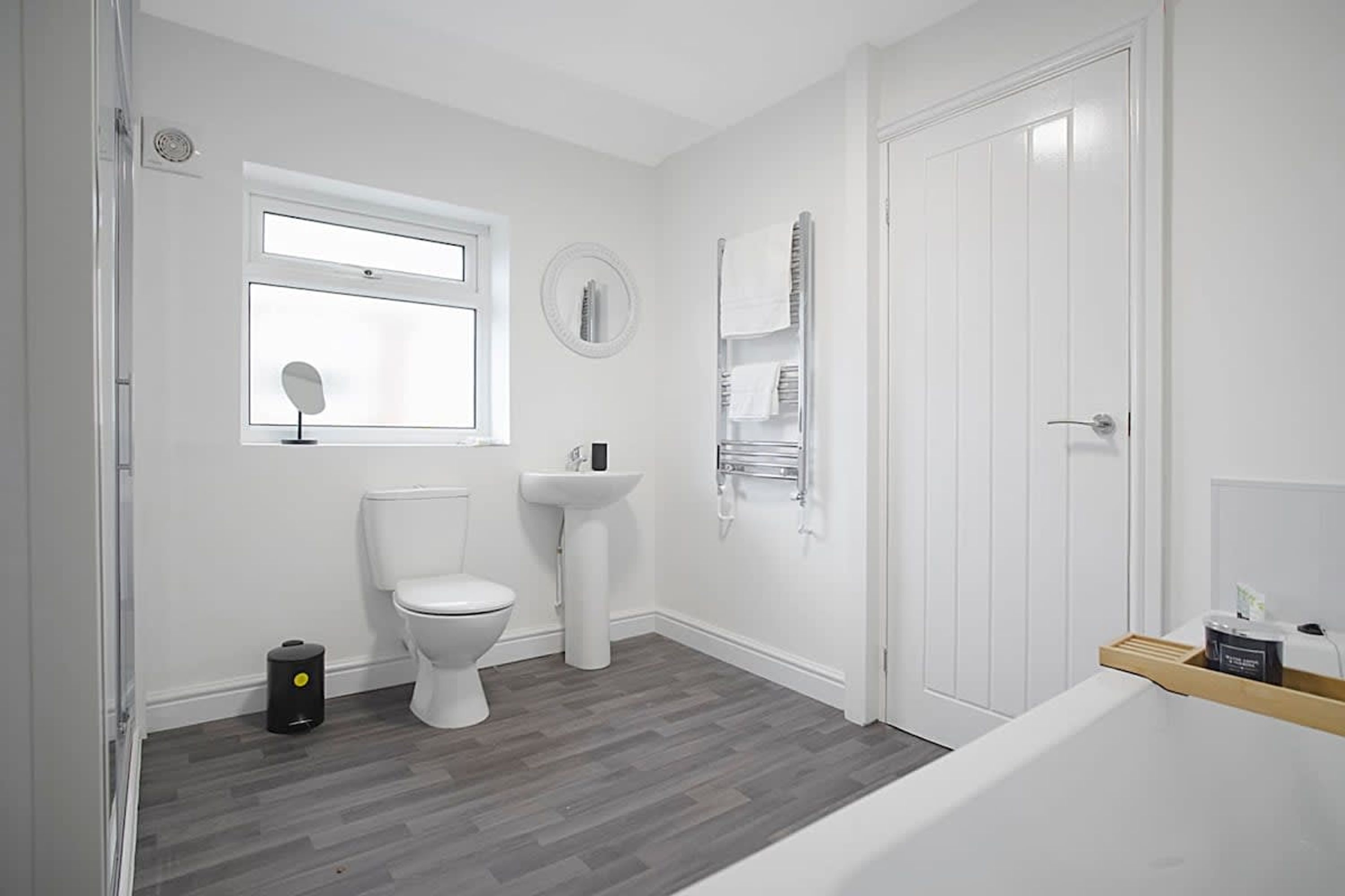 A modern bathroom with a toilet, sink, and mirror.