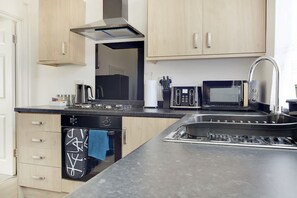 A modern kitchen with a built-in oven, microwave, and sink. - Central Darlington Sleeps 5 For Work or Leisure (Darlington)
