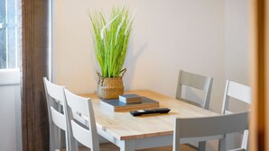 A dining table with four chairs, a remote control, and a woven basket with green plants. - 4BR in Stafford Place Sleeps 7 Wifi Free Parking (Peterlee)