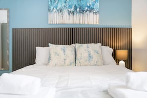 A hotel room with a bed, a headboard, a painting, a lamp, and a mirror. - 4BR in Stafford Place Sleeps 7 Wifi Free Parking (Peterlee)