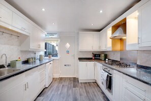 A modern kitchen with white cabinetry, a stainless steel sink, and a built-in oven. - 4BR in Stafford Place Sleeps 7 Wifi Free Parking (Peterlee)