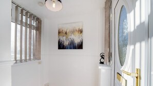 A hallway with a wooden floor, a white door with a glass panel, and a painting on the wall. - 4BR in Stafford Place Sleeps 7 Wifi Free Parking (Peterlee)