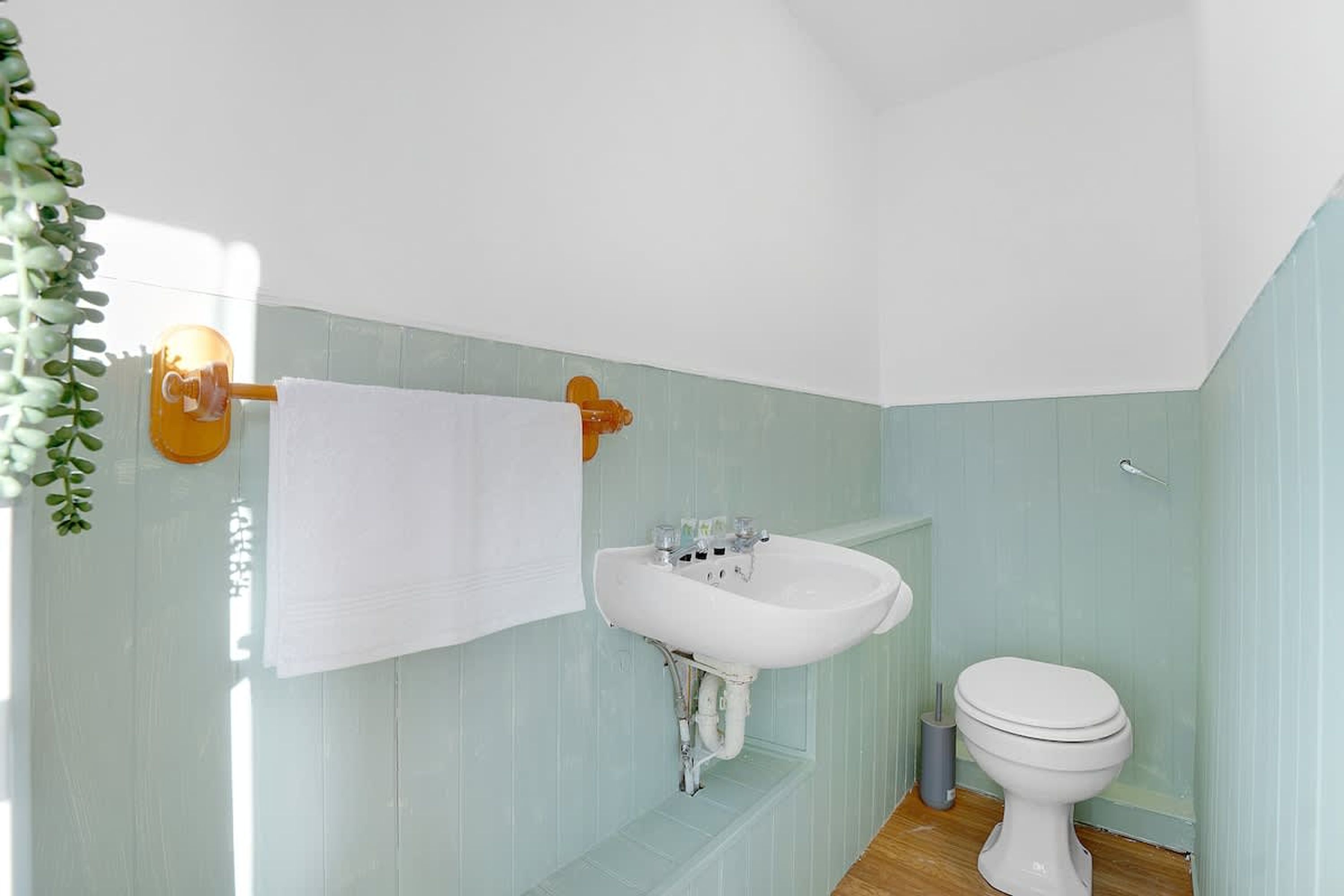 Une salle de bain avec un lavabo blanc, des toilettes et un porte-serviettes.