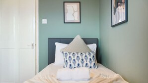 A bedroom with a bed, pillows, and a framed picture on the wall. - Charming 3 Bedroom Home Near Coast Town (Redcar)