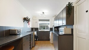 A modern kitchen with a toaster, microwave, and a sink. - Charming 3 Bedroom Home Near Coast Town (Redcar)