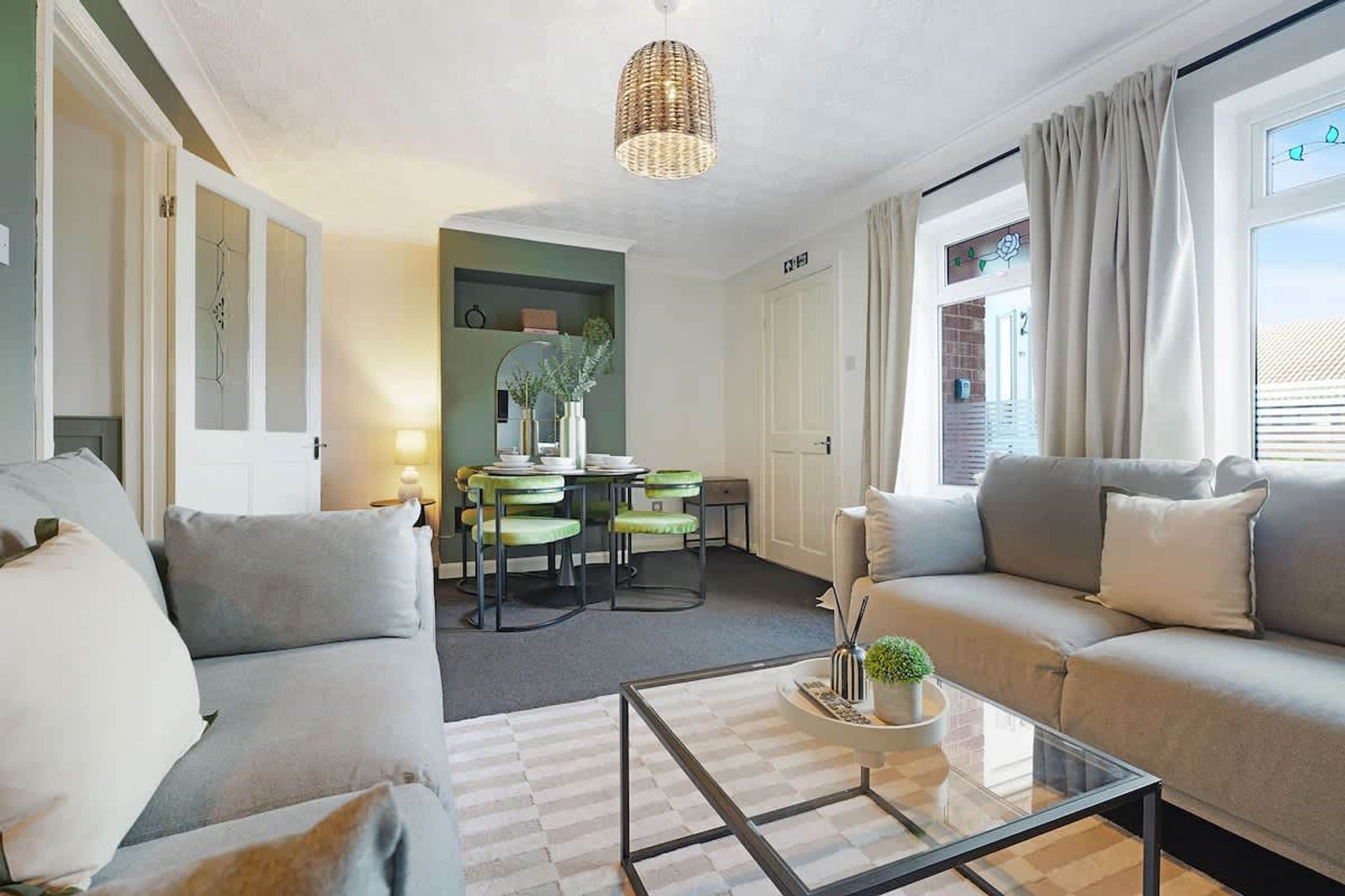 Un salon moderne comprenant un ensemble de canapés, une table basse en verre et un coin repas avec des chaises et une table.