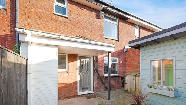 A residential property with a garage, a small garden, and a wooden fence. - Charming 3 Bedroom Home Near Coast Town (Redcar)
