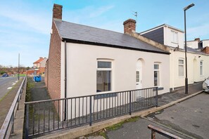 A single-story building with a flat roof, a brick chimney, and a white facade. - Sunderland 3BR Retreat Sleeps 6 by Stay With Us (Sunderland)
