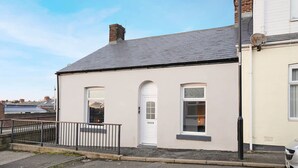 A two-story building with a white facade, a grey roof, and a black metal fence. - Sunderland 3BR Retreat Sleeps 6 by Stay With Us (Sunderland)