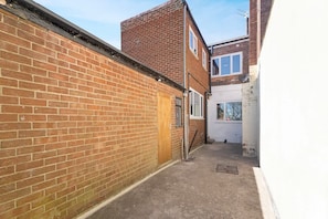 A narrow alleyway with a brick wall on one side and a building with a window on the other. - 5BR Sleeps 10 Perfect for Contractors in Durham (Durham)