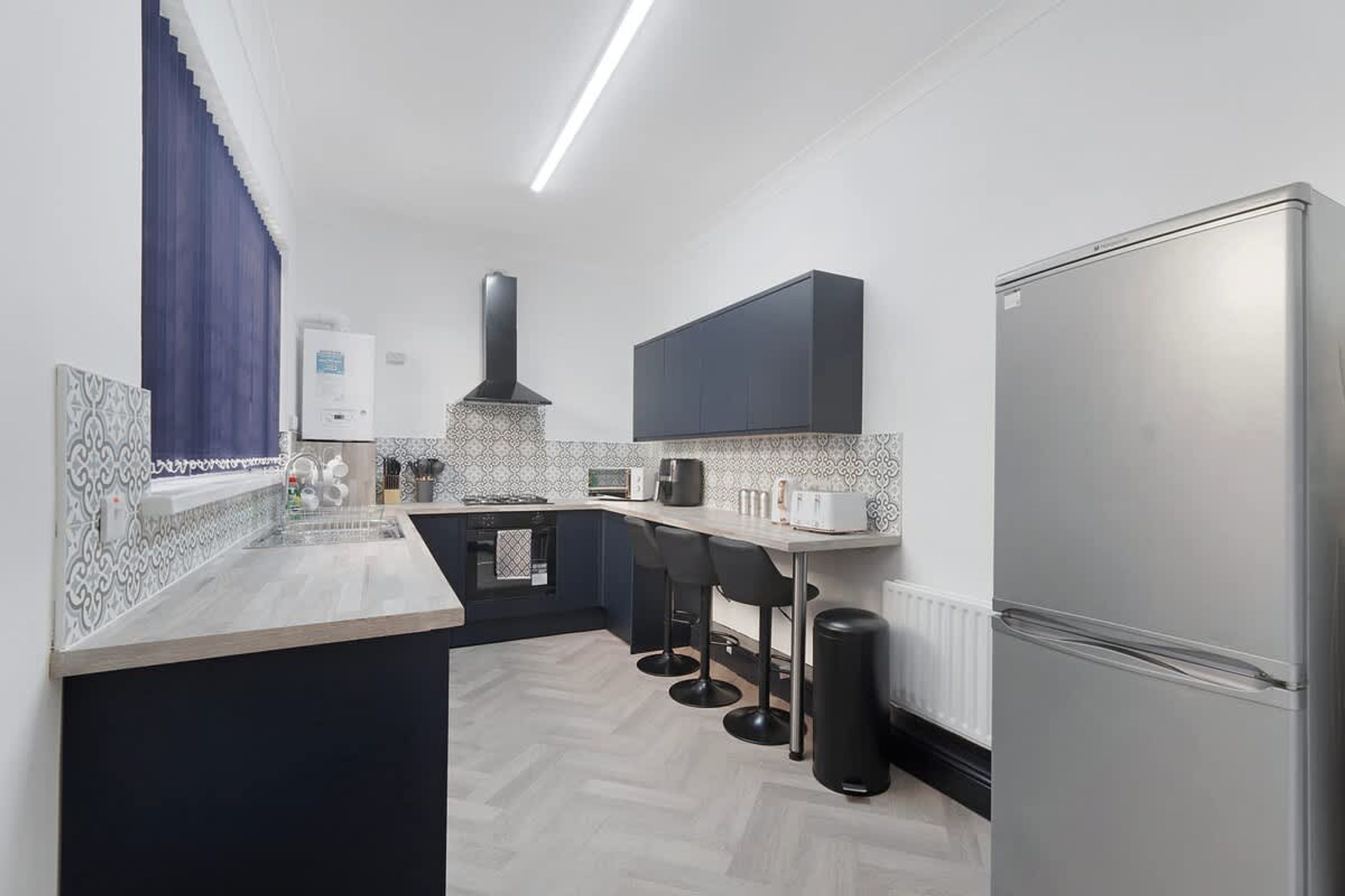 A modern kitchen with a built-in oven, a microwave, and a refrigerator.