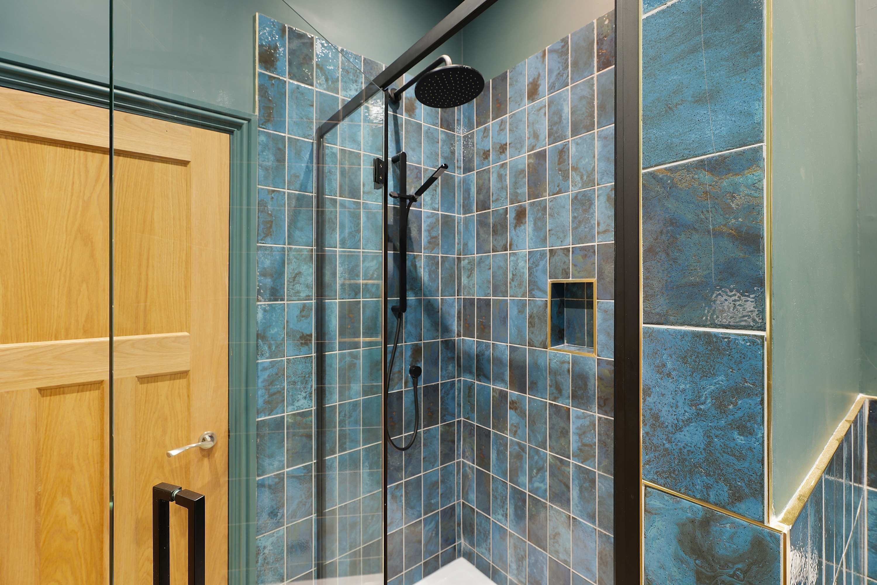 A shower with a handheld showerhead and a wall-mounted rain showerhead.