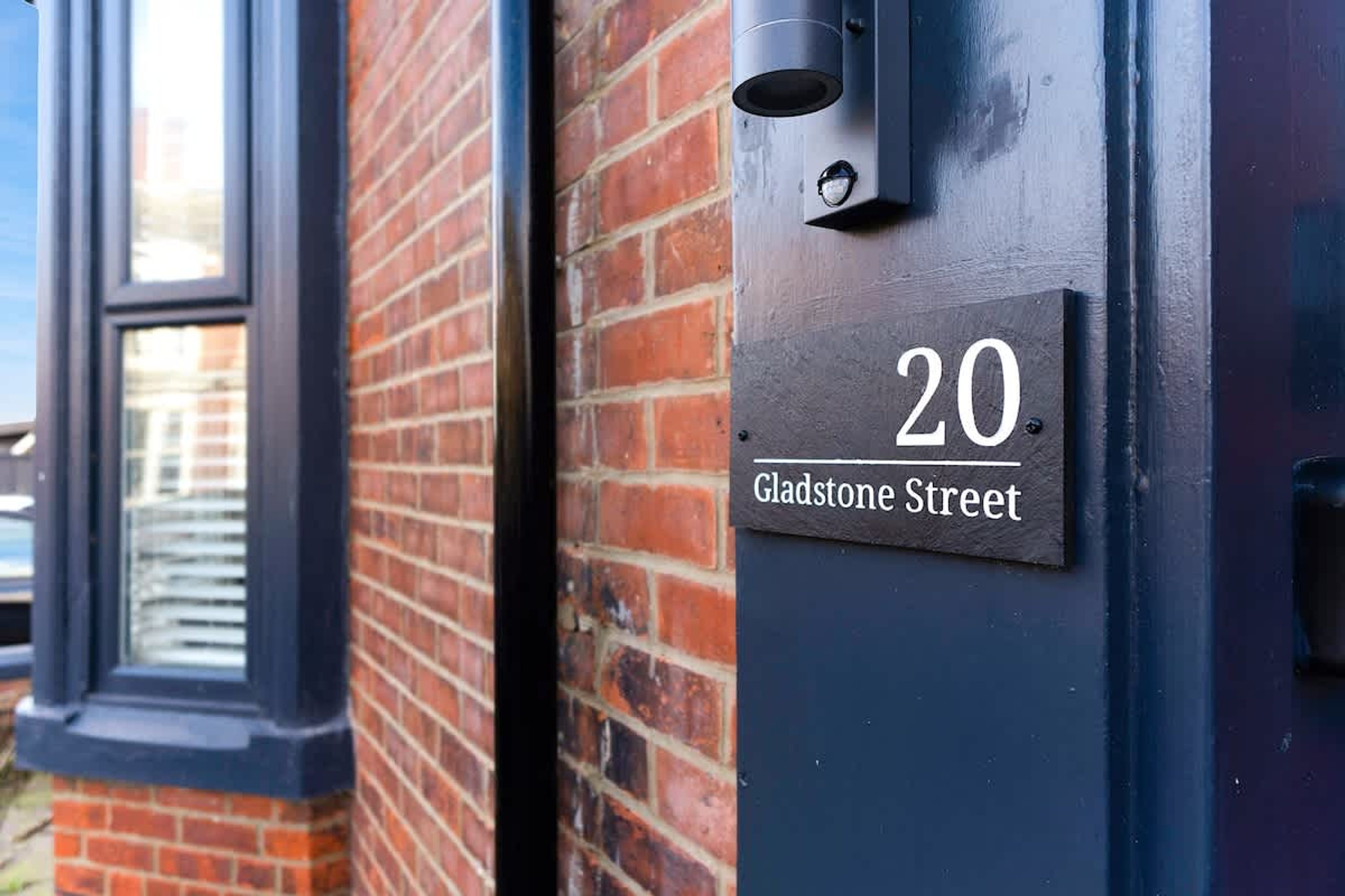 Le numéro 20 est affiché sur une maison, sur un mur de briques, avec une fenêtre à gauche.