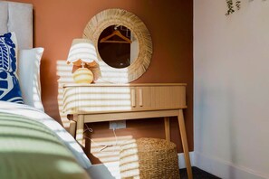 A bedroom with a bed, a bedside table with a lamp, a mirror, and a hanging plant. - Central Hartlepool 2BR Retreat Sleeps 3 by Stay With Us (Hartlepool)