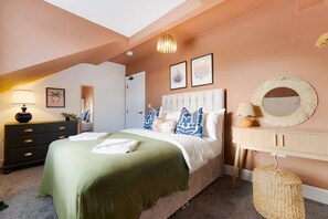 A bedroom with a bed, bedside tables, a dresser, a mirror, and a ceiling light. - Central Hartlepool 2BR Retreat Sleeps 3 by Stay With Us (Hartlepool)