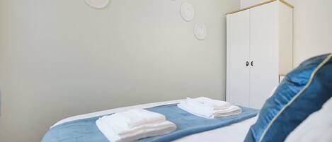 A bedroom with a bed, a wardrobe, and a wall with circular decorations.