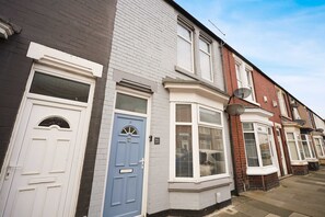 A row of terraced houses with distinct front doors, some with numbers and others with mailboxes. - Charming 3 Bed Steps From Redcar Beach and Station (Redcar)