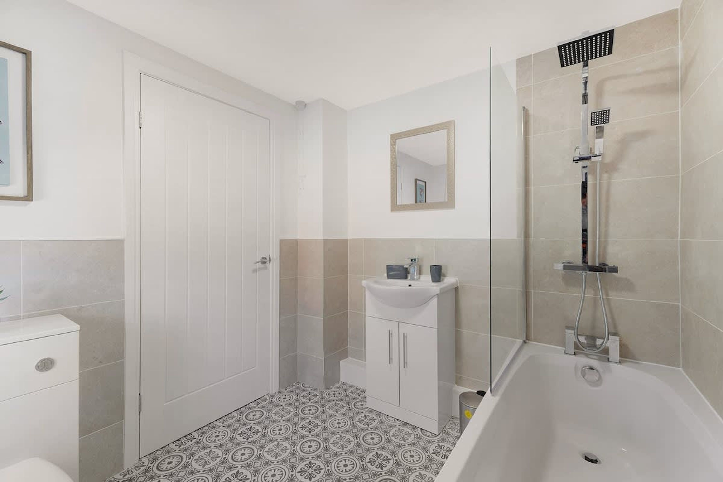 A bathroom with a shower, toilet, and sink.