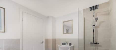A bathroom with a shower, toilet, and sink.