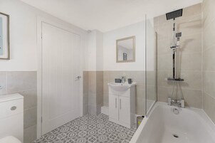 Un baño con ducha, inodoro y lavamanos.