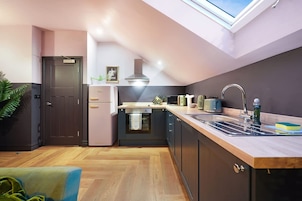 Una cocina moderna con tragaluz, refrigerador, estufa y lavaplatos.