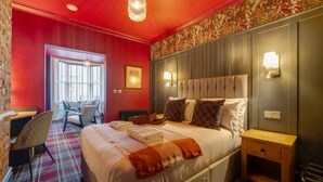 Una camera d'albergo con un letto grande, una scrivania e una sedia.