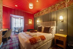 Ein Hotelzimmer mit einem großen Bett, einem Schreibtisch und einem Sessel.
