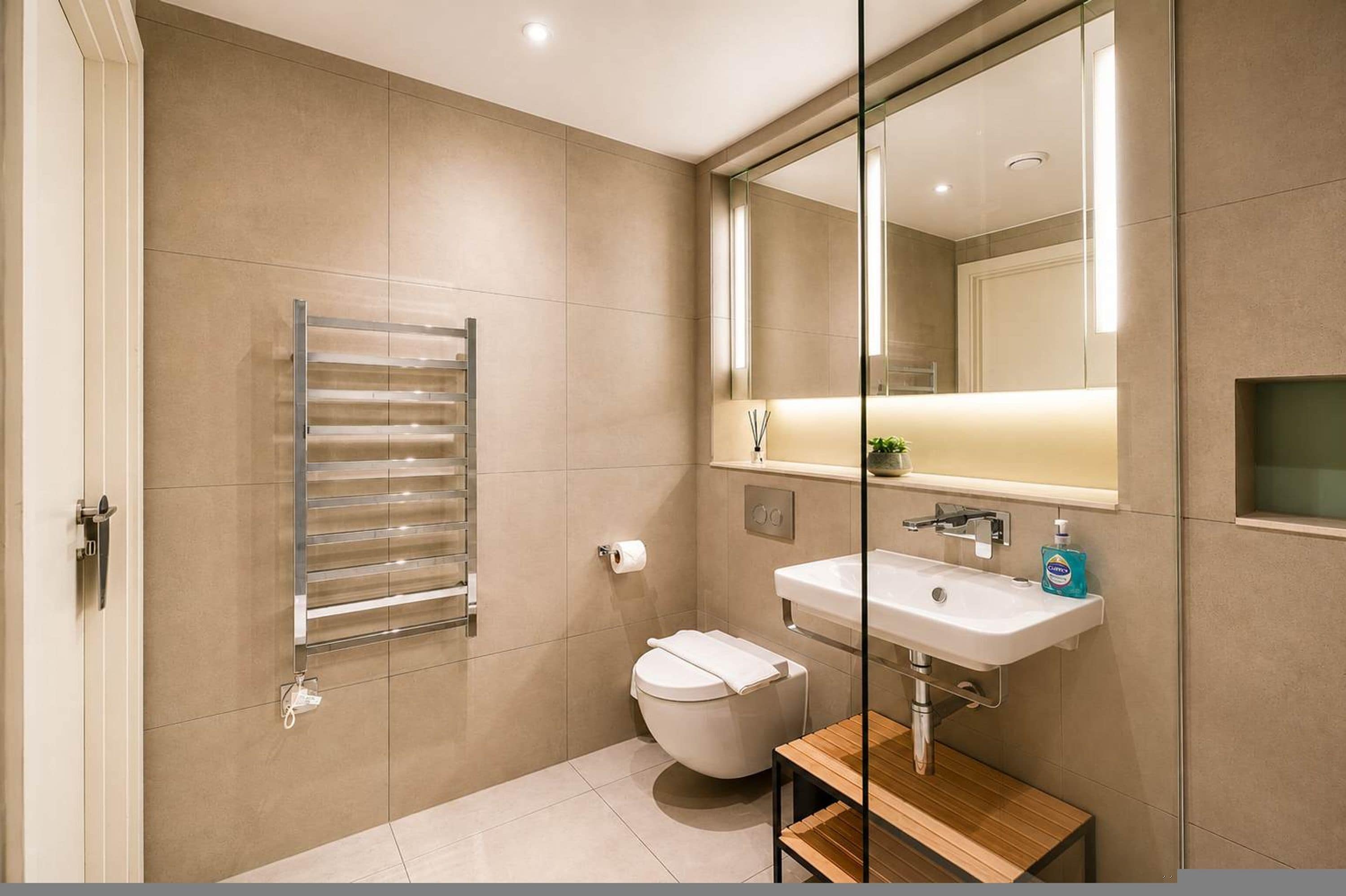 A modern bathroom with a toilet, sink, and towel rack.