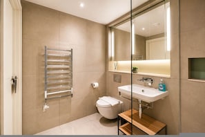 A modern bathroom with a toilet, sink, and towel rack.