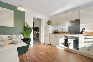 A modern kitchen with white cabinets, a stainless steel range, and a wooden countertop. - Modern Coastal Stay Minutes From Redcar Beach (Redcar)