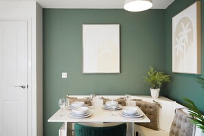 Ein Essbereich mit einem Tisch für vier Personen, einem Blumentopf und Bildern an der Wand.