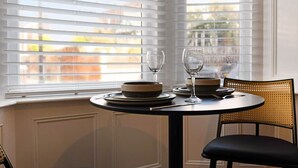 A dining area with a table set for two, two wine glasses, and plates. - Hartlepool Marina Retreat 2BR Sleeps 4 by Stay With Us (Hartlepool)